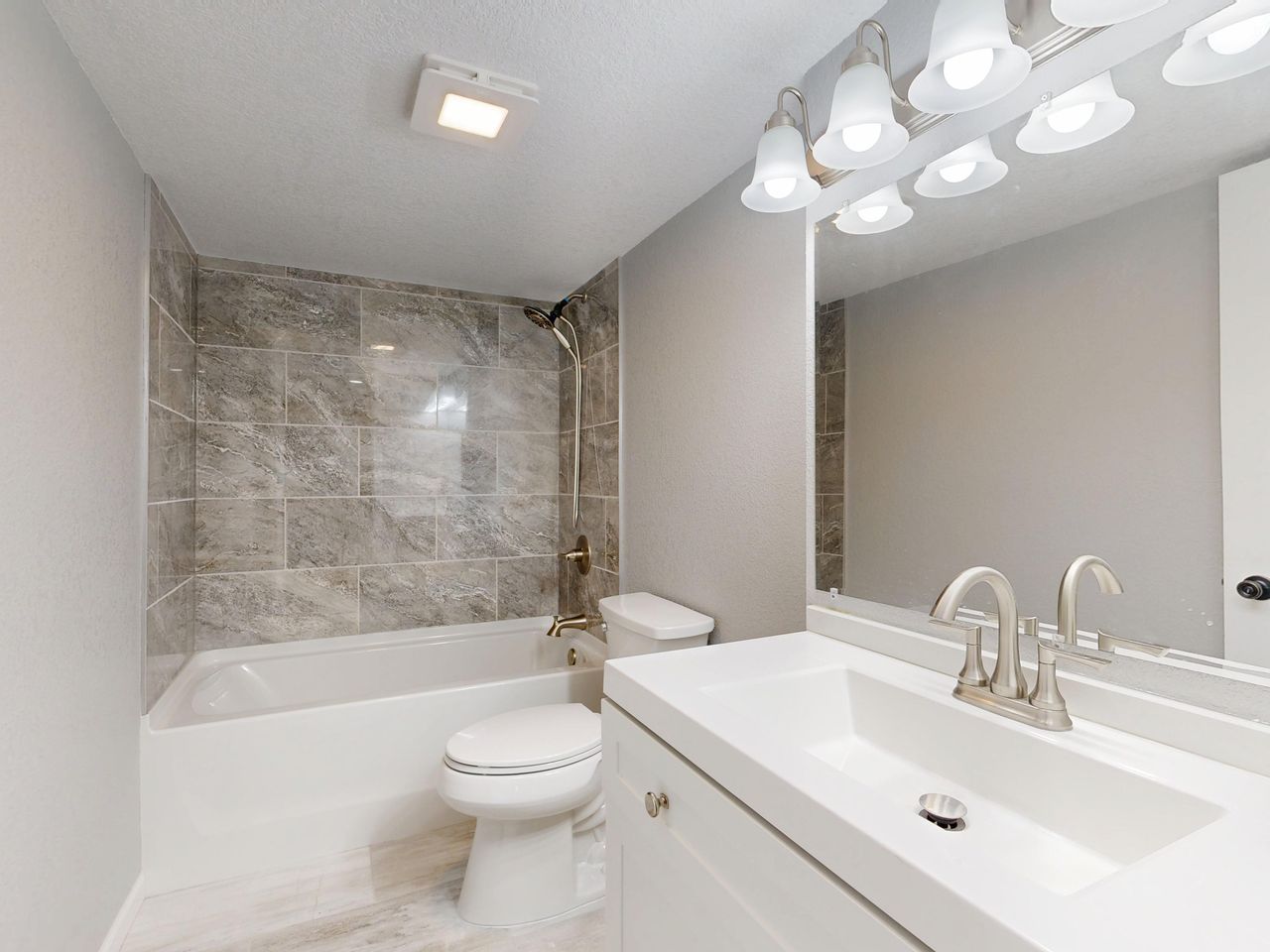 creative-approach-img Elegant modern bathroom featuring marble tiles and sleek white vanity.
